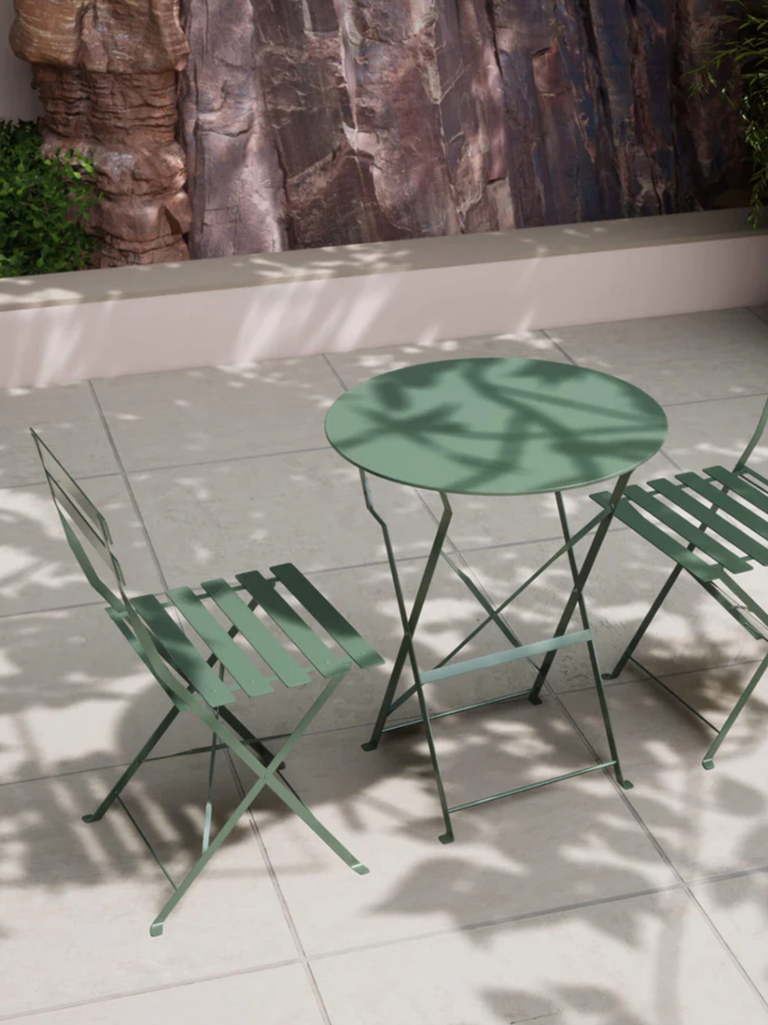 a green bistro table in a garden