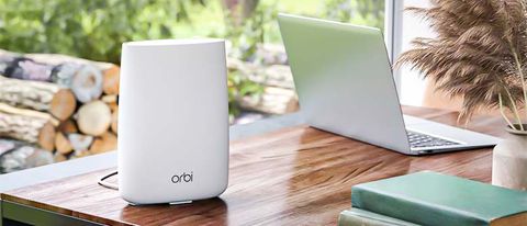 Netgear Orbi LBR20 on desk next to laptop