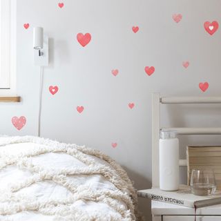 white bedroom with heart wall decals and white table