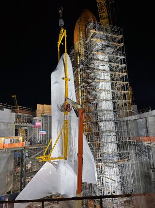 The winged orbiter Endeavour, covered in shrink wrap, is attached to its external tank and twin solid rocket boosters inside the work site of the Samuel Oschin Air and Space Center in Los Angeles on Tuesday, Jan. 30, 2024.