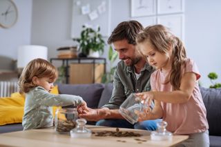 children counting money out of jars with their father