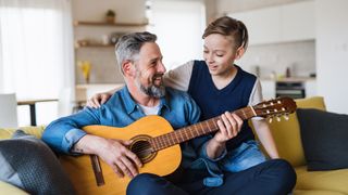 Father playing guitar with his daughter