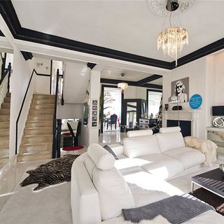 living area with white sofa and white wall and staircase