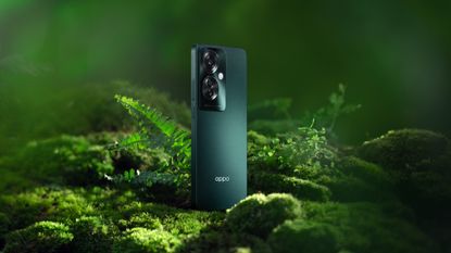 The Oppo Reno 11 F in palm green on a green, leafy background