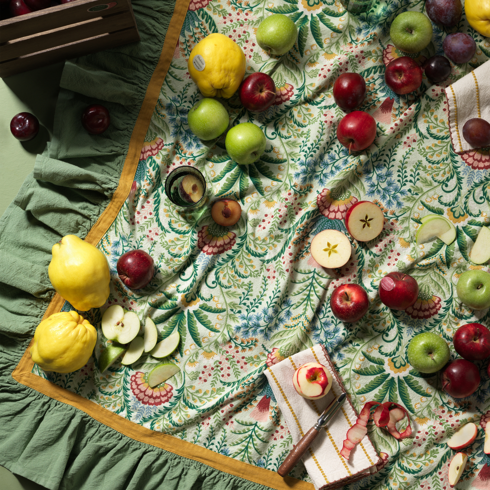 habitat x sanderson & national trust tablecloth with apples, napkins and lemons on top.