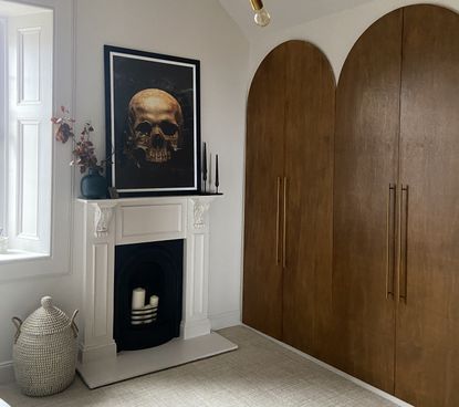 A bedroom with a fireplace and a large closet with wooden arched doors