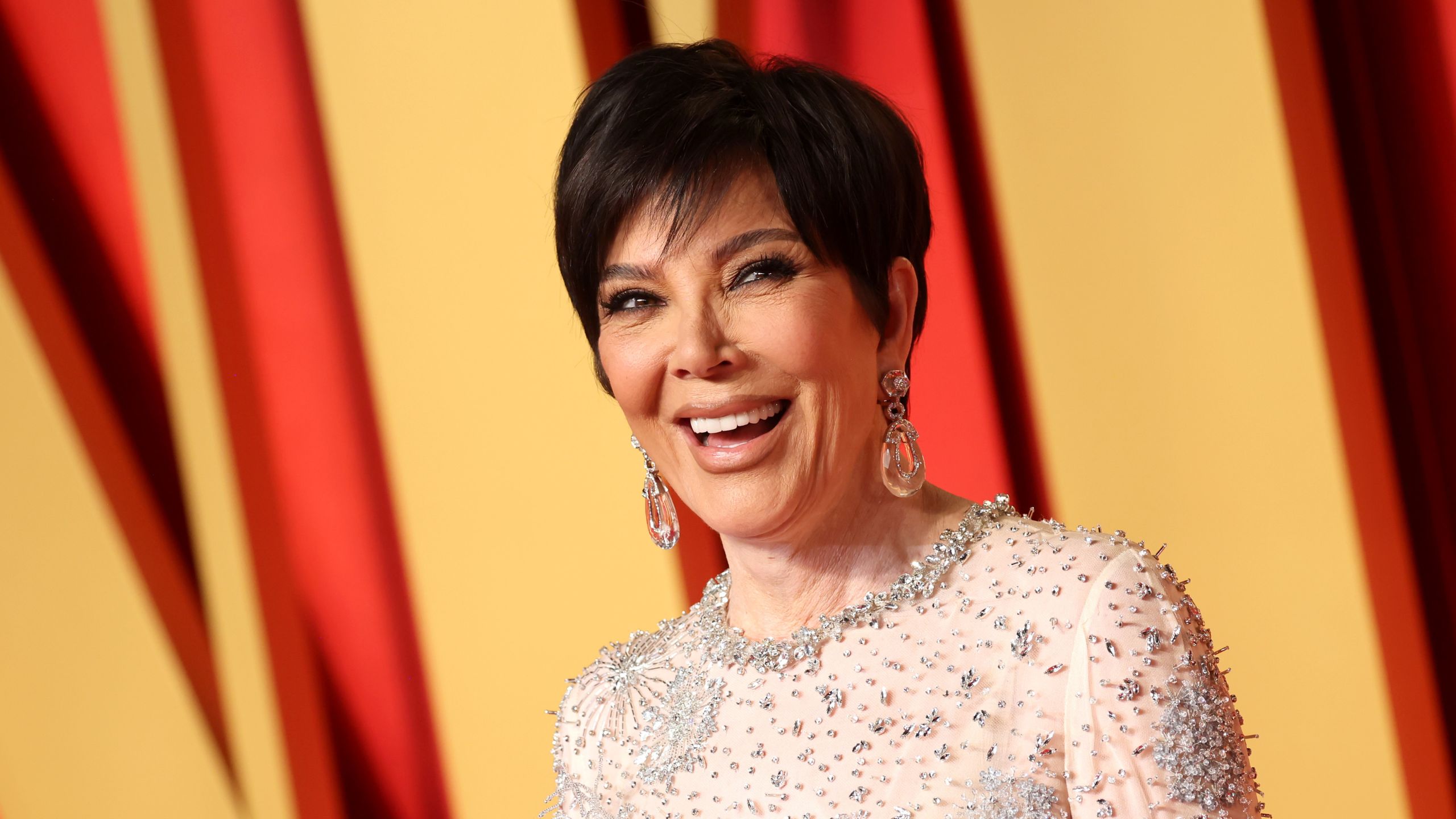 Kris Jenner on a red and yellow background