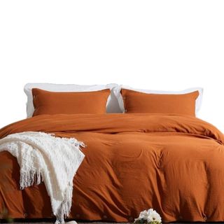 An orange bedding set on a bed