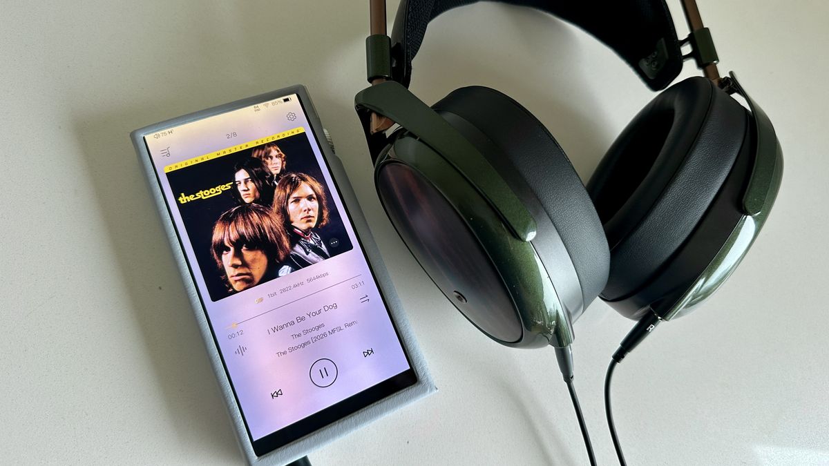 Meze Audio Strada headphones with wooden ear cups, in close-up and with their case and cables visible, on a white table