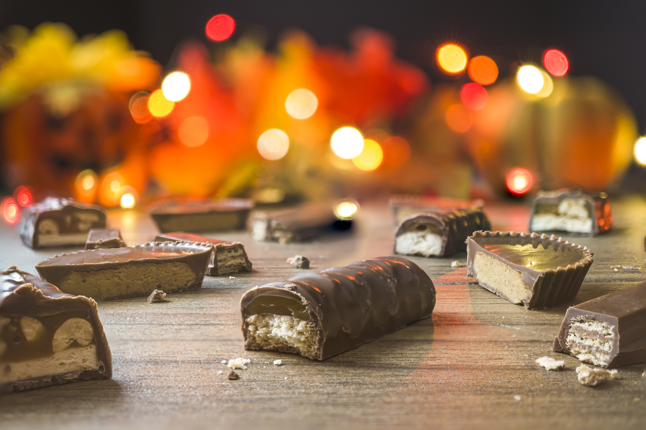 Pieces of chocolate candy bars with autumnal lights in the background.