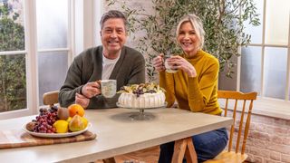 John and Lisa sitting at a table for John and Lisa&#039;s weekend kitchen season 9