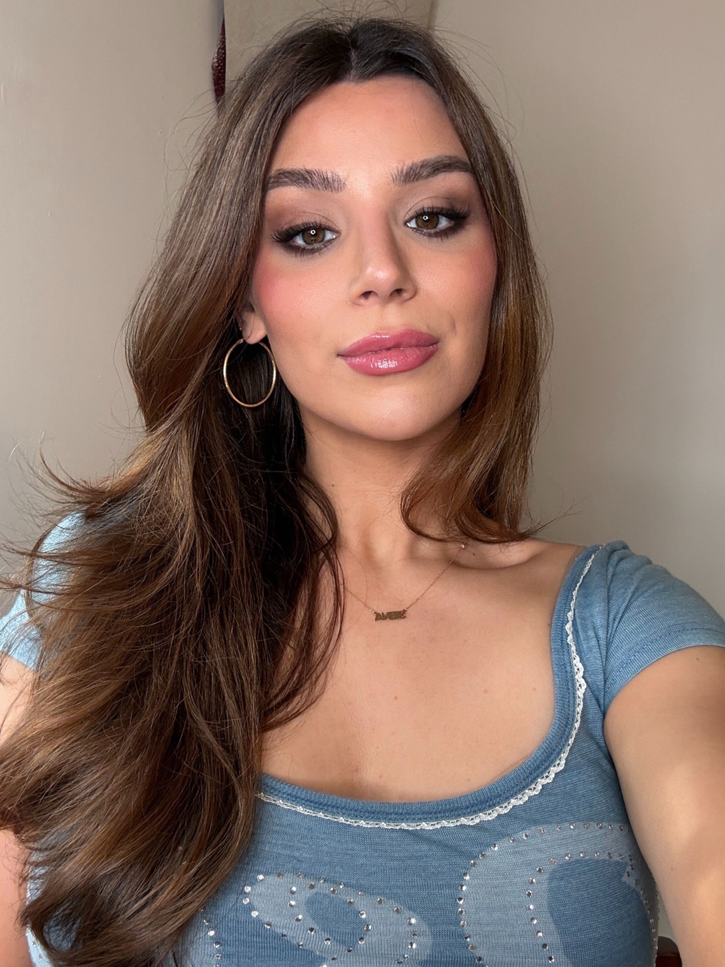 siena gagliano with the YSL Make Me Blush Cream Blush in 44 Nude Lavalli&amp;egrave;re with a blue shirt and long brown hair