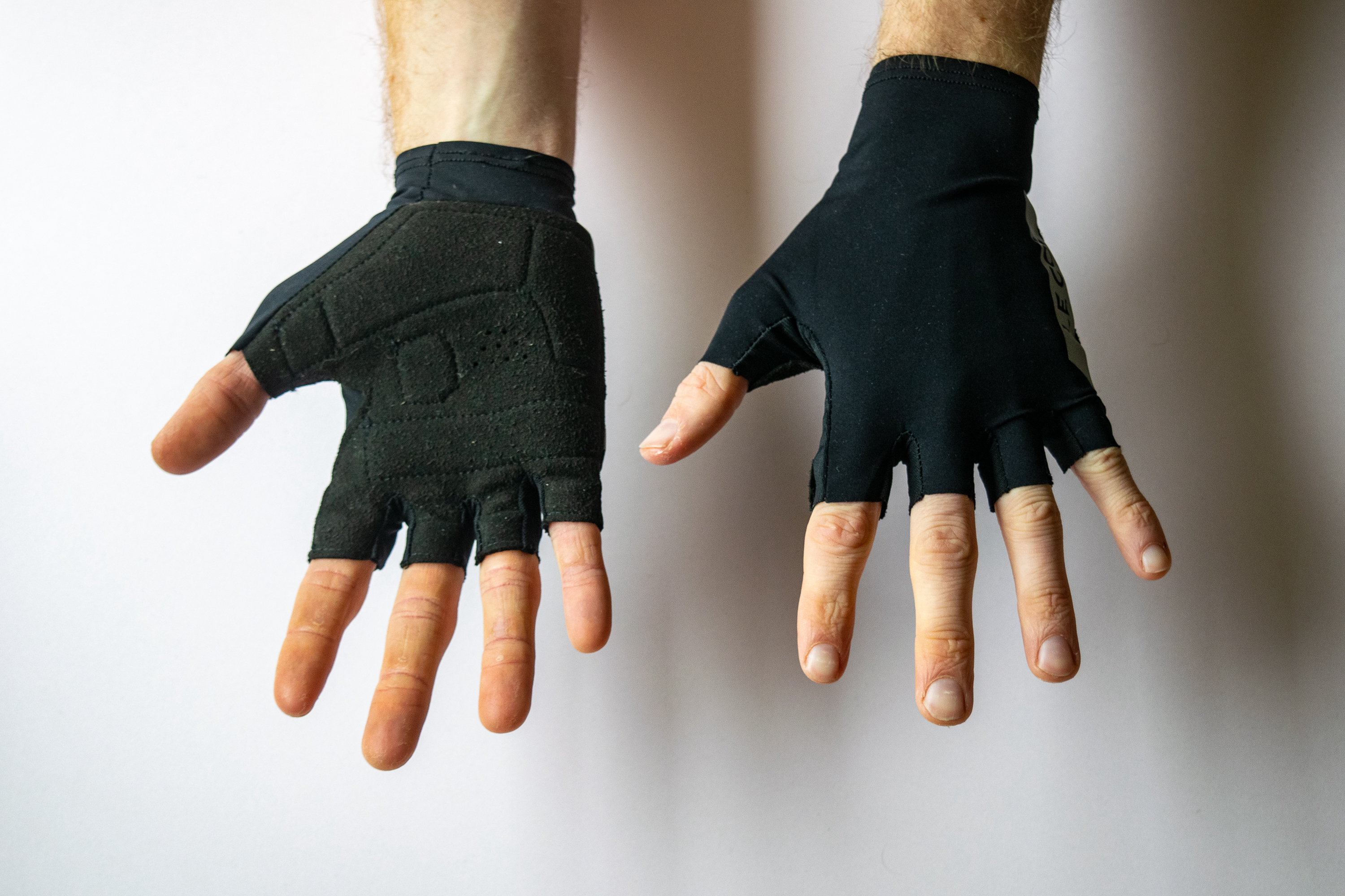A rider wearing Le Col summer cycling gloves with hands showing the palm and face of the gloves
