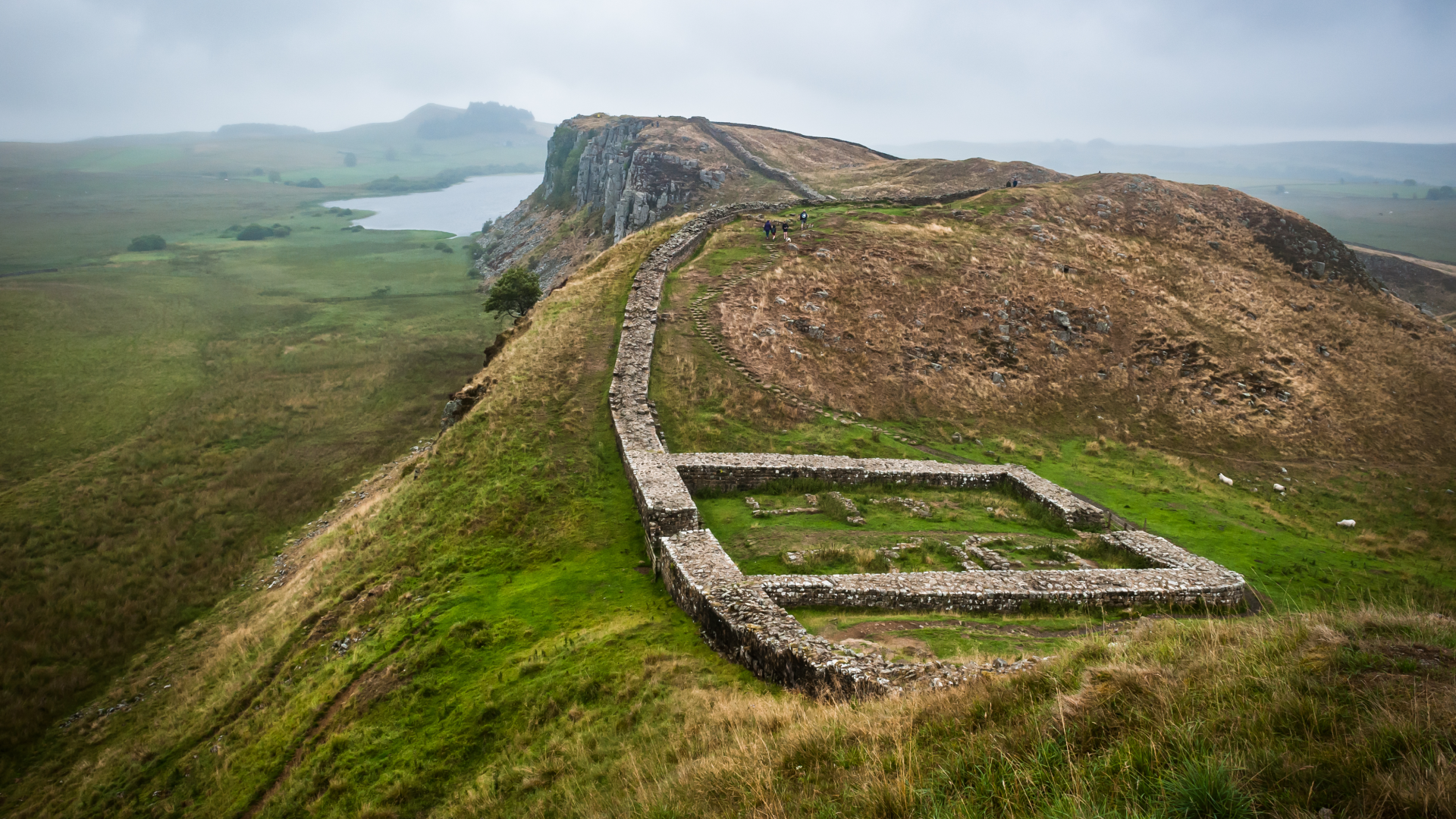a series of small walls in a lush, mountainous landscape