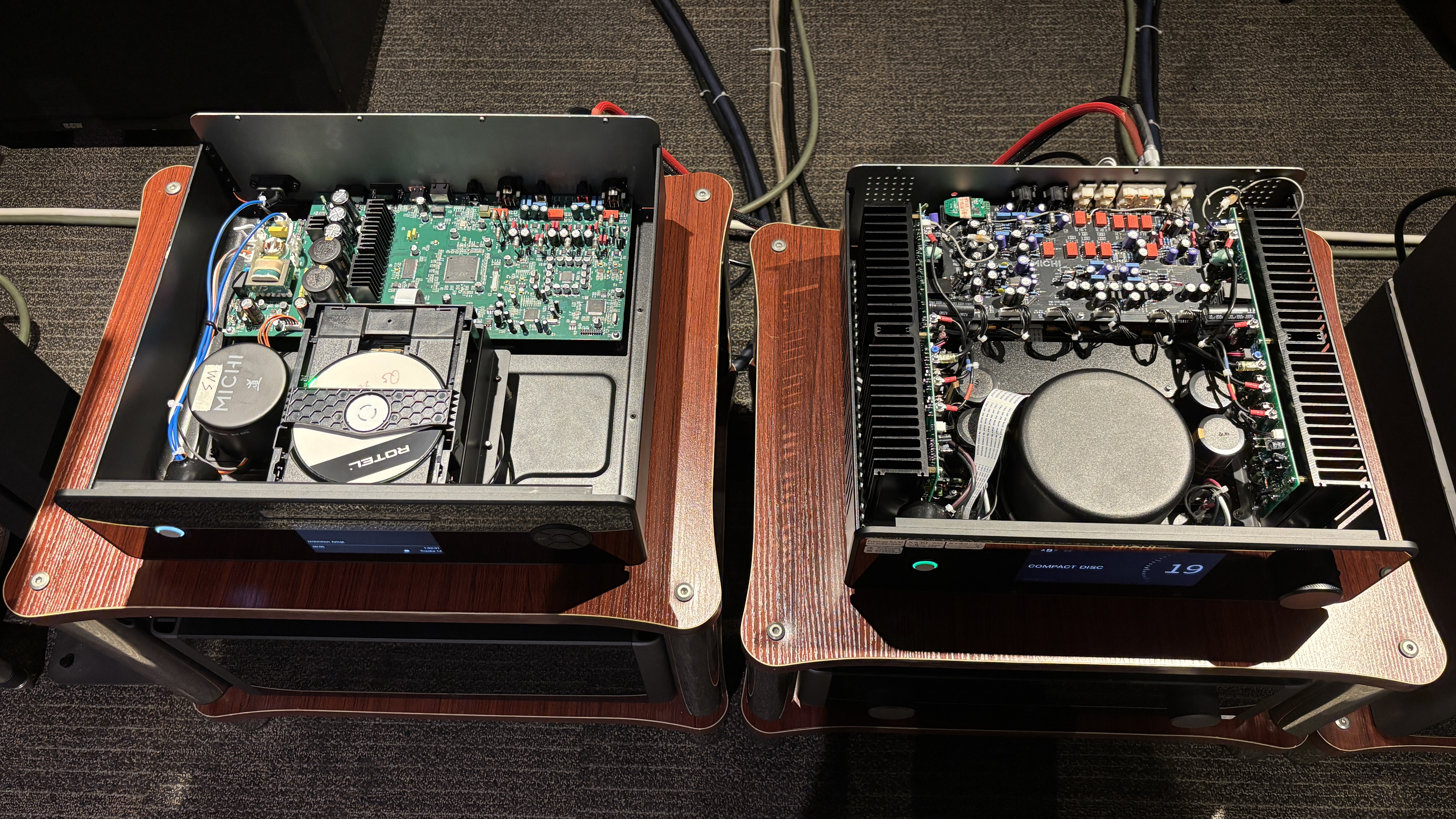 Rotel Michi Prestige X430 and C430 on hi-fi stands with their covers open exposing the components inside