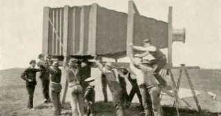 Old photograph of several men supporting a giant camera