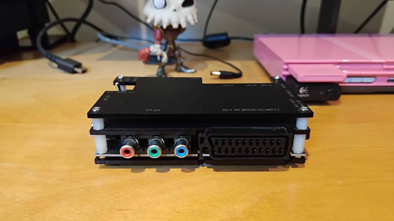 OSSC on bench with SCART and component inputs facing forward.