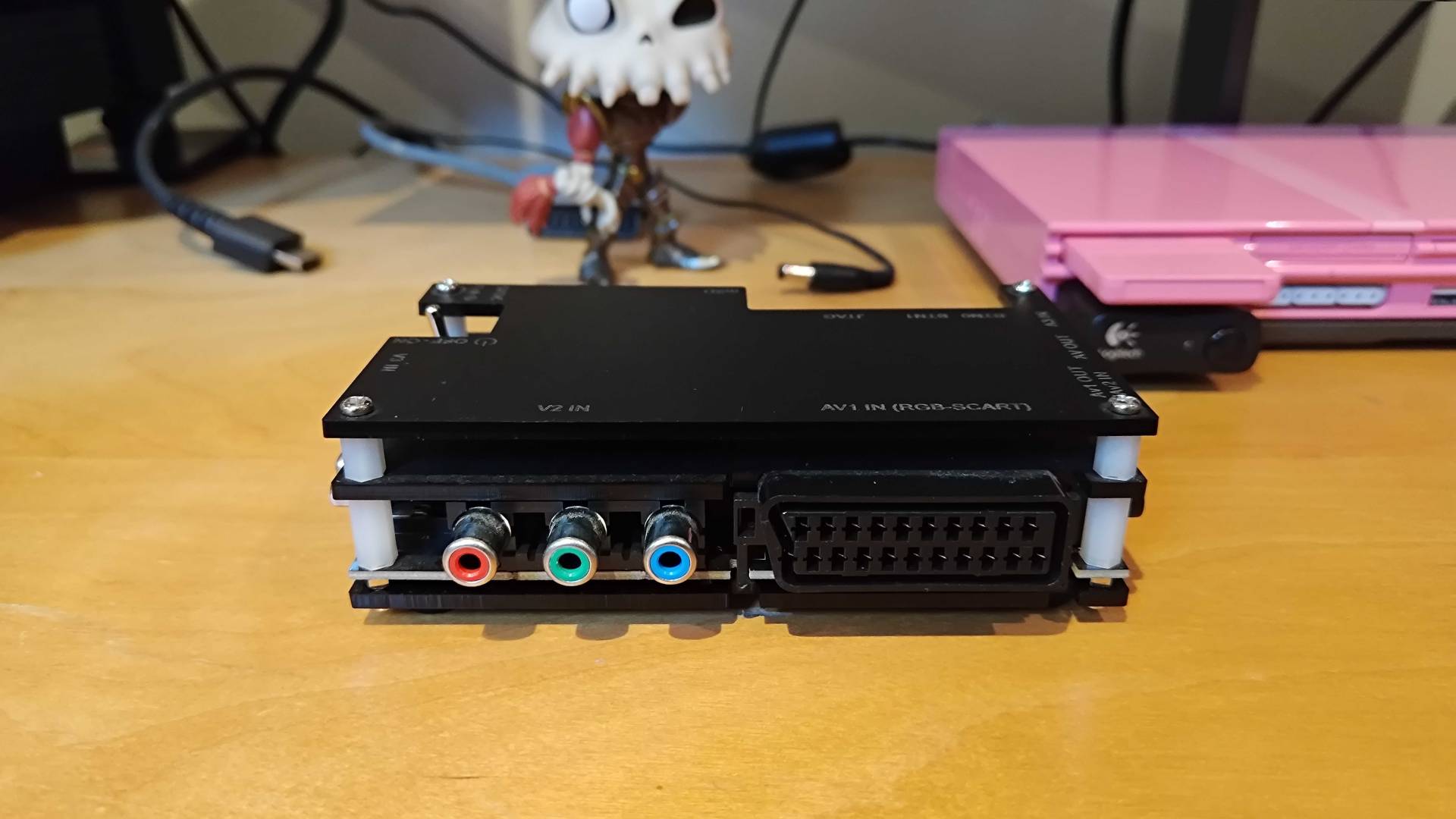 OSSC on bench with SCART and component inputs facing forward.