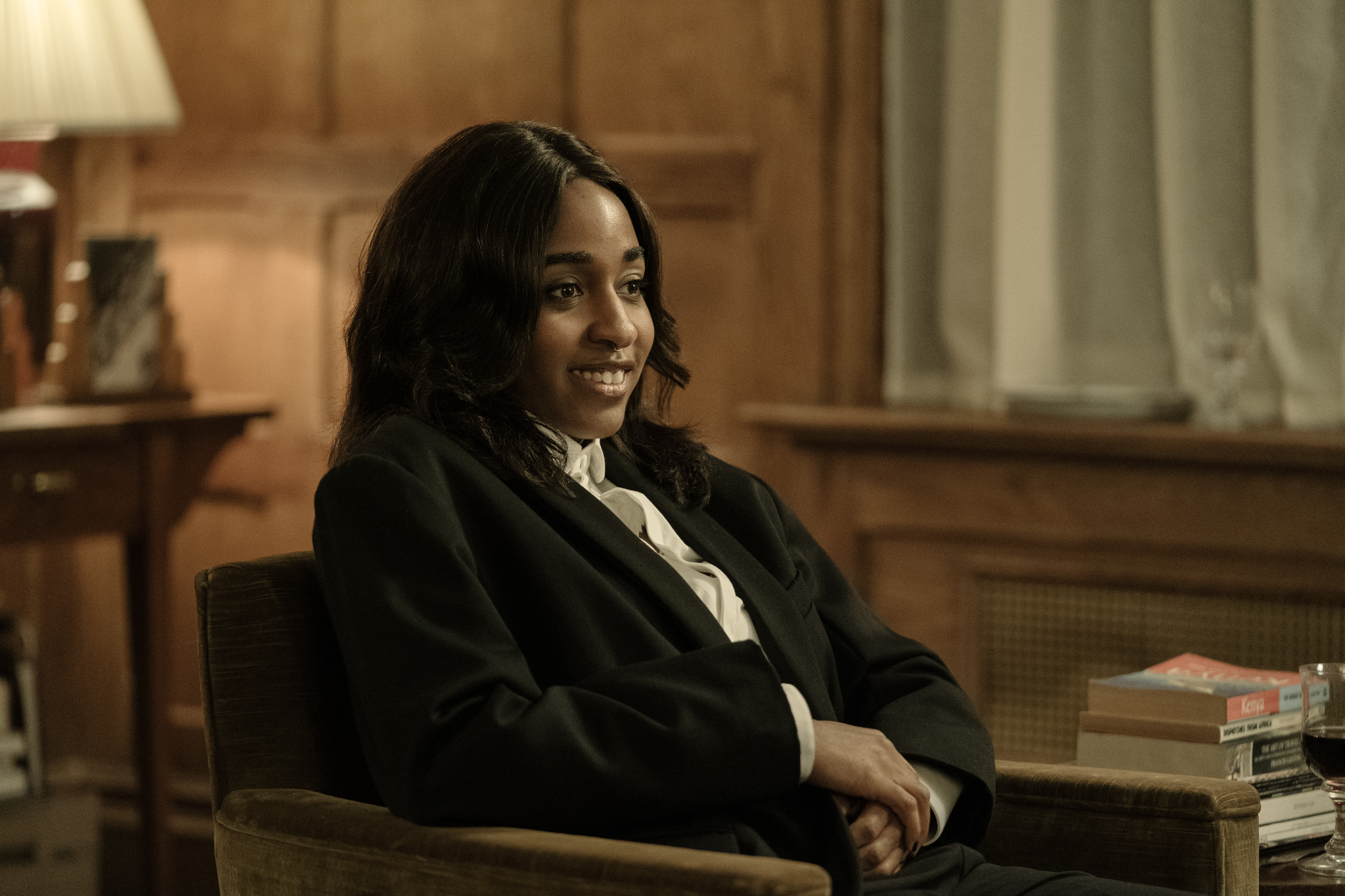 ayo edebiri as maggic wearing a blazer sitting in a chair in after the hunt