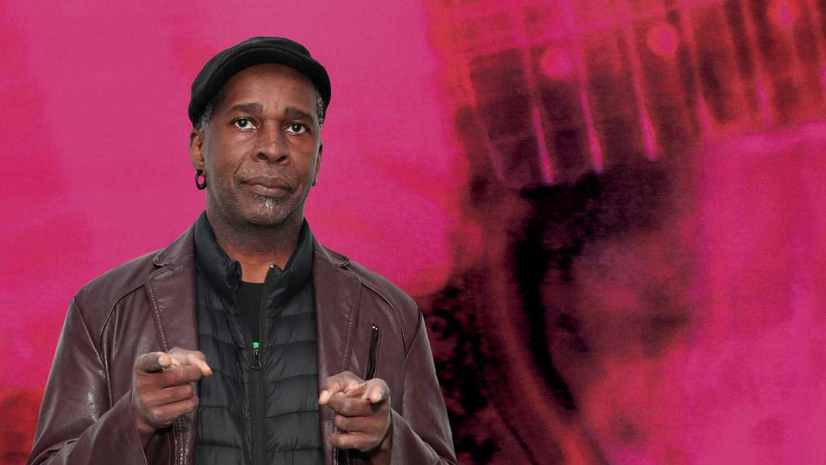 Vernon Reid standing in front of the cover art for My Bloody Valentine&#039;s Loveless