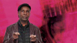Vernon Reid standing in front of the cover art for My Bloody Valentine's Loveless