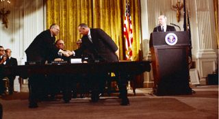 President Lyndon B. Johnson and USSR Ambassador Anatoly Dobrynin shaking hands at the signing ceremony for the Outer Space Treaty, January 27, 1967.