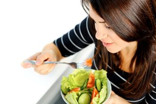 A woman eats a salad
