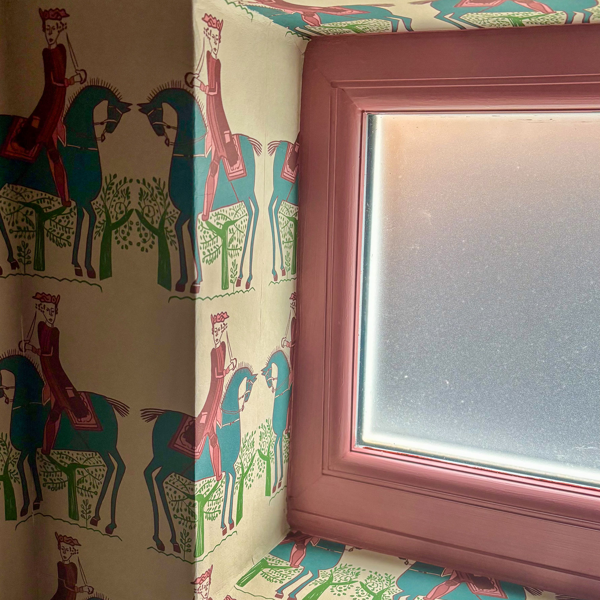 Pink window frame surrounded by patterned wallpaper