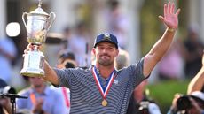 Bryson DeChambeau salutes the fans with the US Open trophy