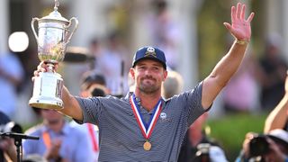 Bryson DeChambeau salutes the fans with the US Open trophy