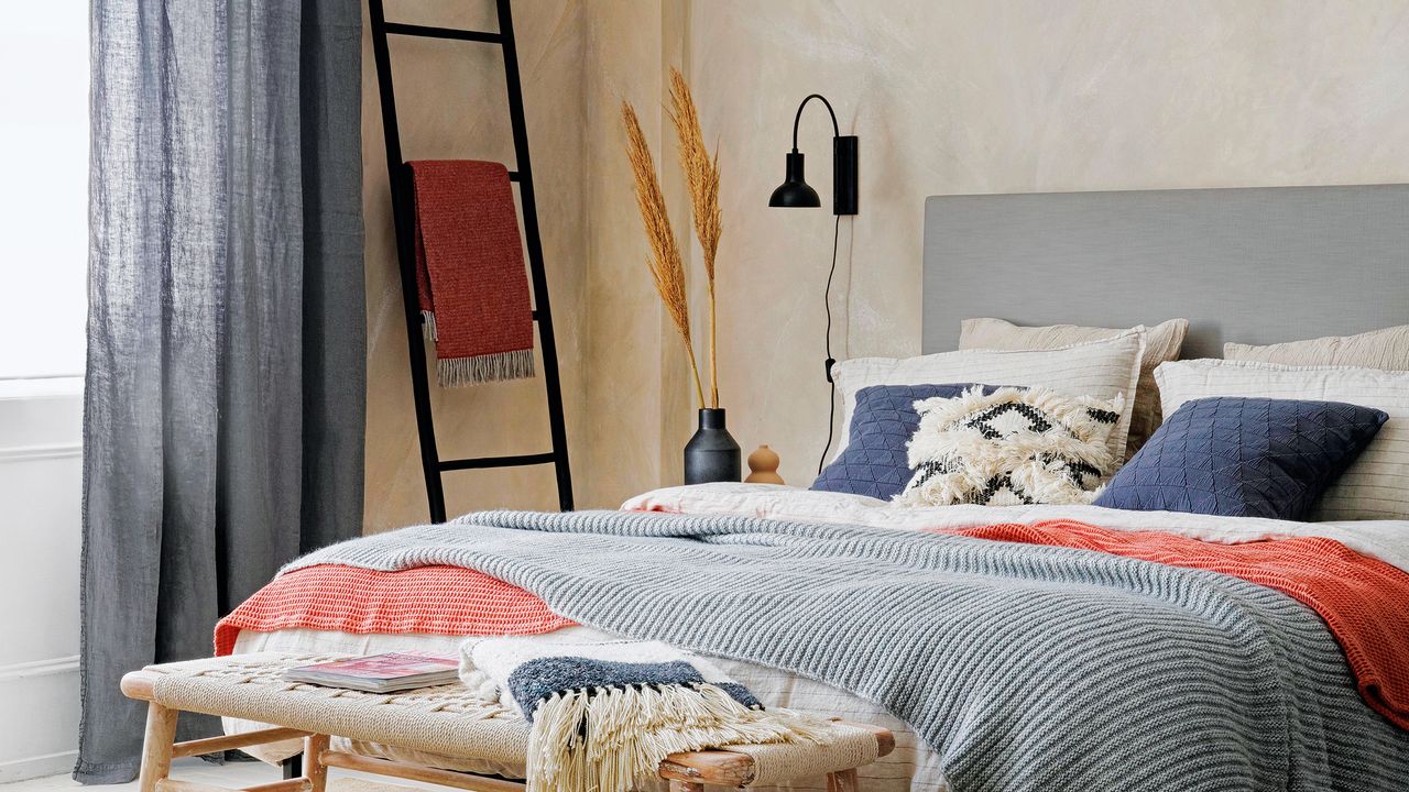 Bedroom with polished plaster walls and a black wall light