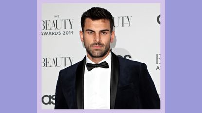 Adam Collard is pictured wearing a black suit as he attends The Beauty Awards 2019 on November 25, 2019 in London, England/ in a purple template