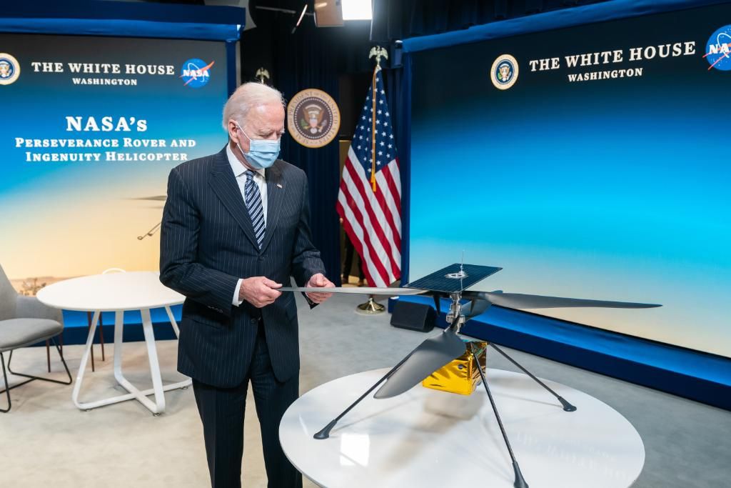 President Joe Biden examines a model of NASA&#039;s Mars helicopter Ingenuity, which on April 19 became the first aircraft to perform a powered, controlled flight on a world beyond Earth.