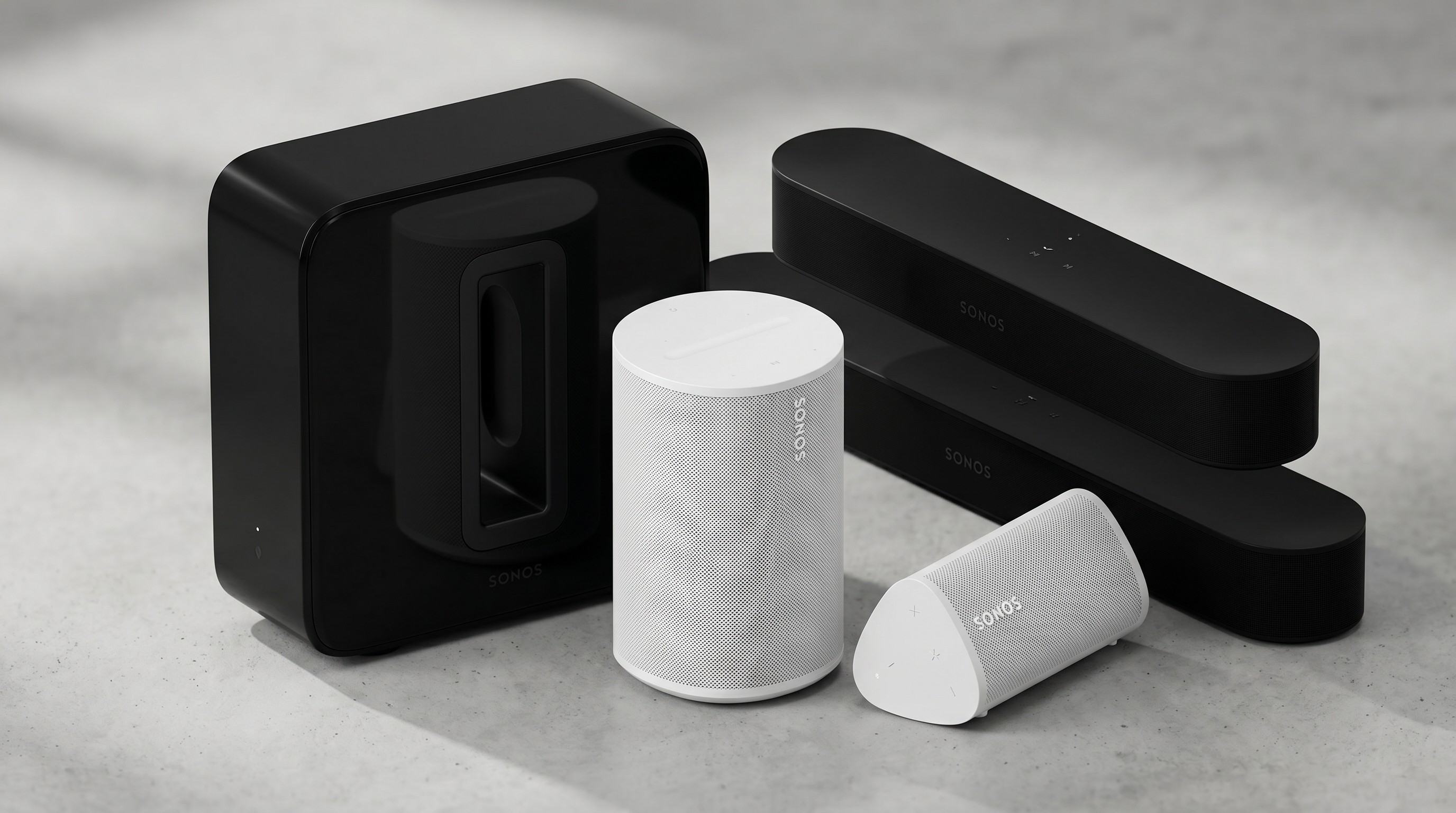 A set of Sonos speakers and soundbars sitting on a granite surface
