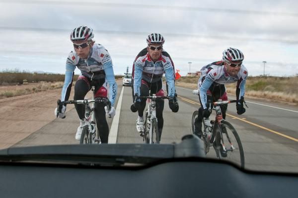 Riders make use the team car to their advantage to catch back on with the main bunch.