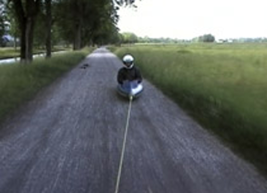 man in a bobsleigh on a road