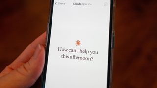 Close-up of a person's hand holding a smartphone and using the Opus 4 model within the Claude app from AI company Anthropic, Lafayette, California, May 22, 2025.