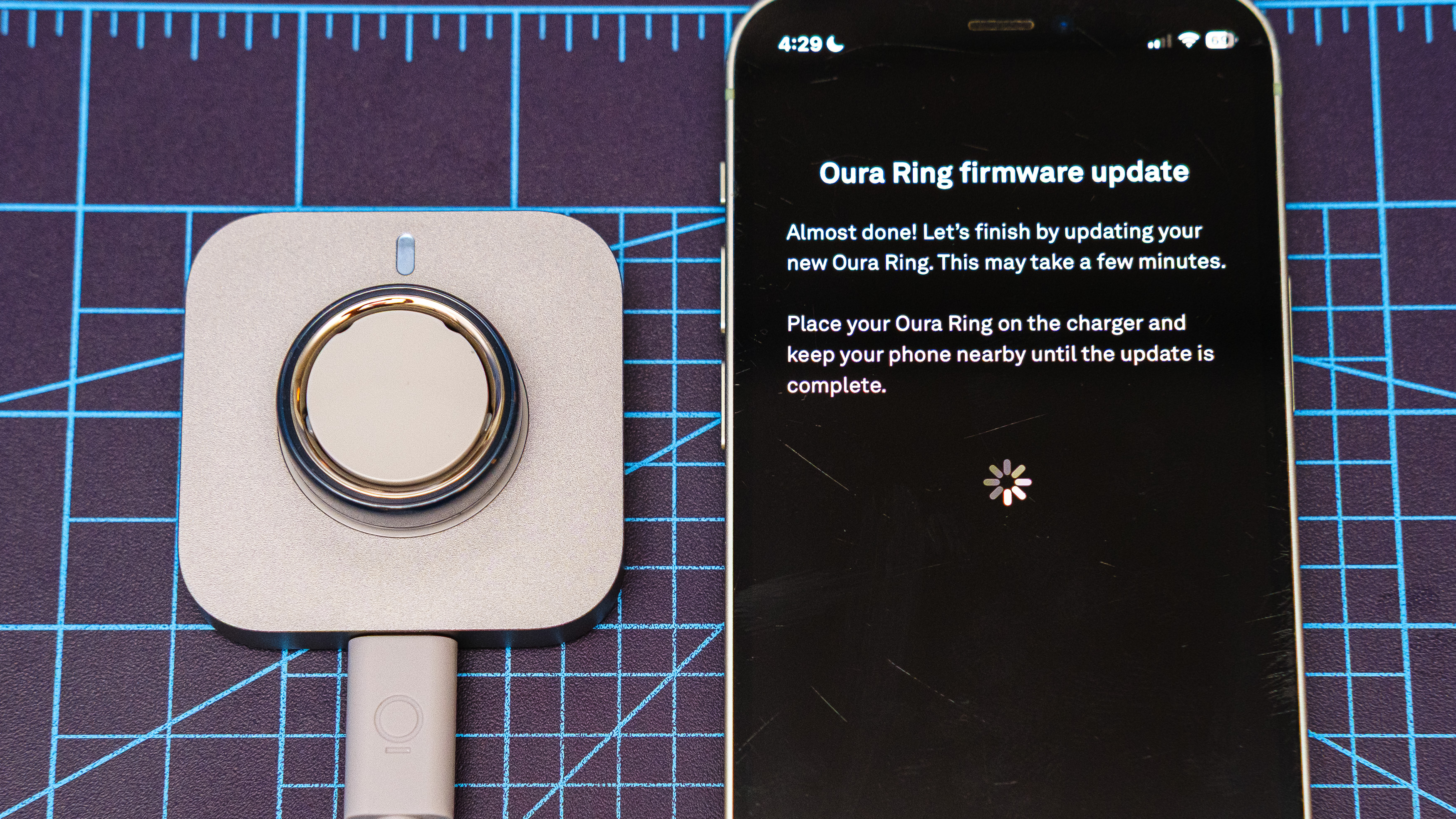 Oura Ring 4 Ceramic close-up showing the setup and pairing process using an iPhone