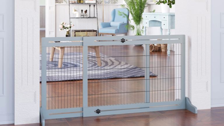 A mesh dog gate with grey frame in a living room