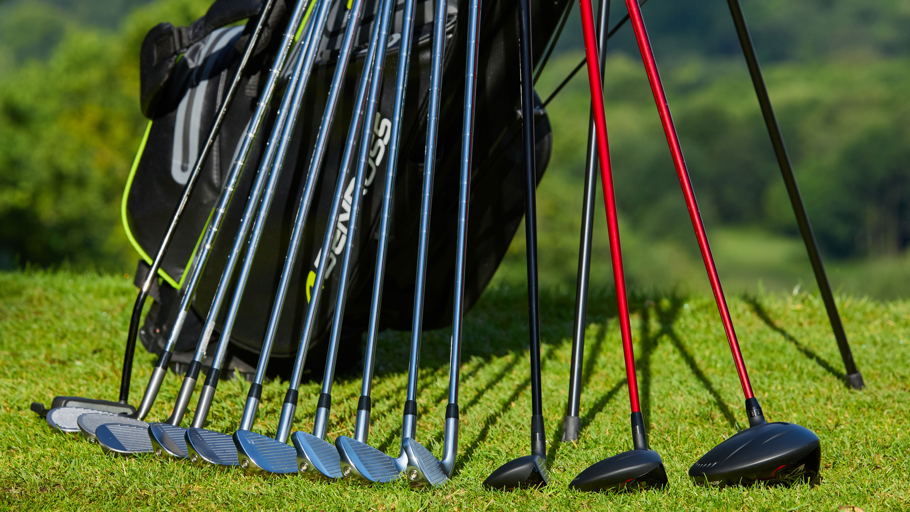 14 golf clubs standing up against a golf bag