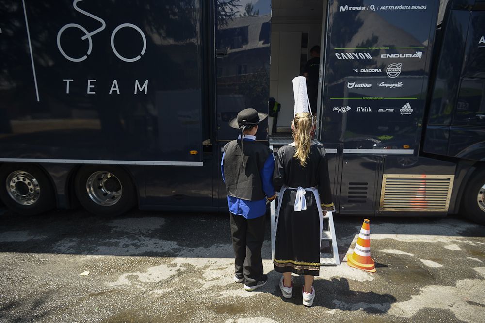 Children dressed with Brittany traditional costumes wait for Spain's Movistar cycling team's water bottles, at the team hotel during a rest day as part of the 102nd edition of the Tour de France.