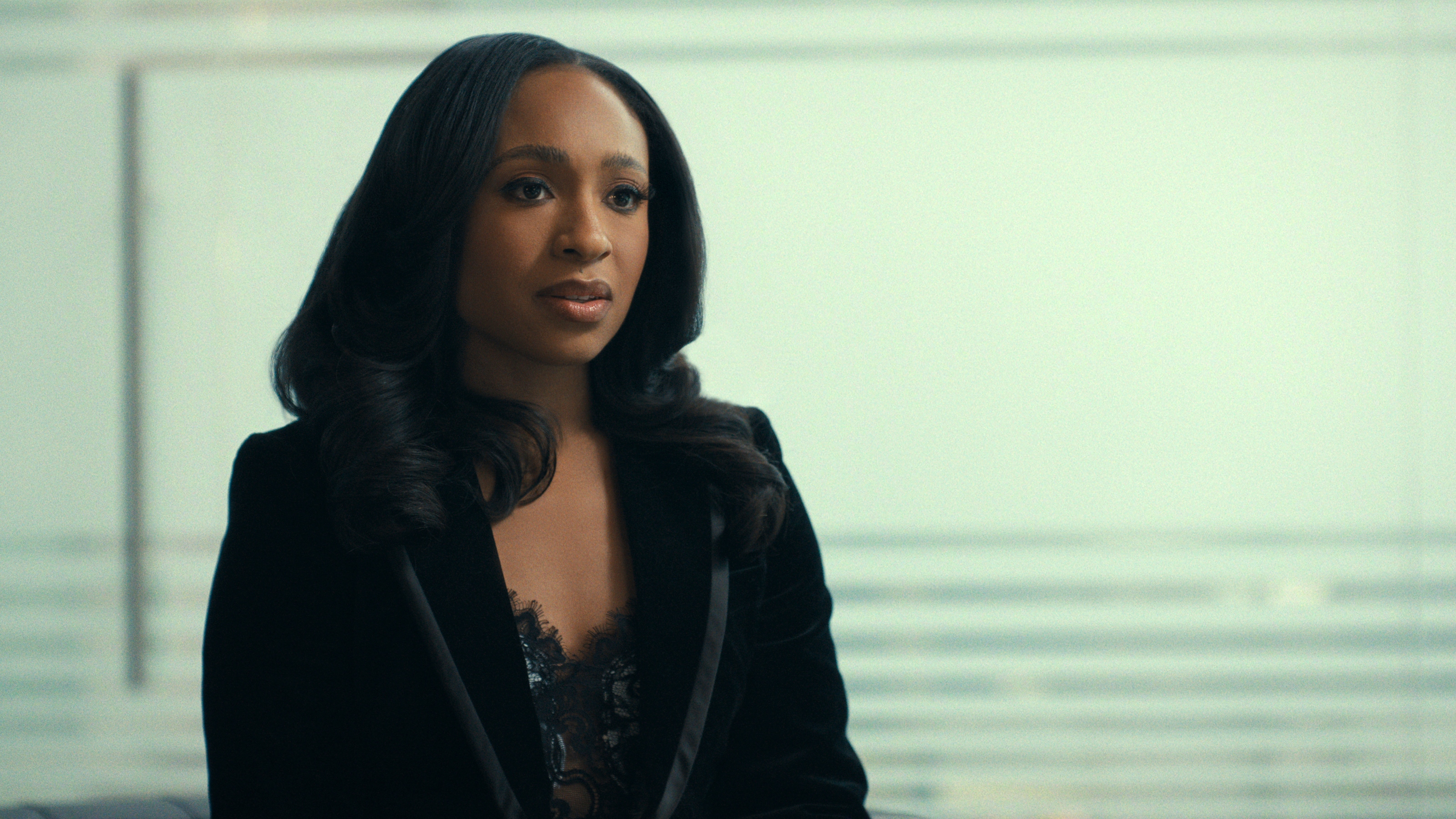 Taylor Polidore Williams as Kimmie wearing a black velvet blazer and lace top.