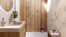 bathroom with timber panelling wall, marble tiles, timber bench with towel and headphones, round mirror, floating vanity with stone benchtop and timber cabinetry