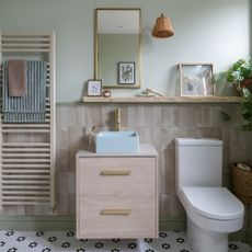 a neutral coloured bathroom with a wooden vanity unit, and matching shelf, mirror, wall light and modern toilet