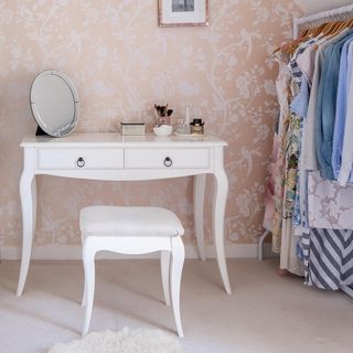 dressing room with feminine blush wallpaper and dressing table