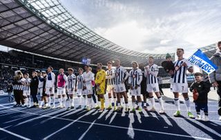 Hertha Berlin players celebrate with the fans at the Olympiastadion after a win over Schalke in March 2024.