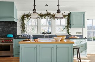 A kitchen with cabinets painted in a light blue color