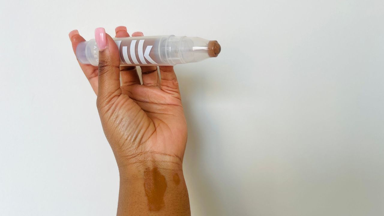A person holding an opened Milk Sunshine Skin Tint SPF 30 for the best tinted moisturizers with SPF.