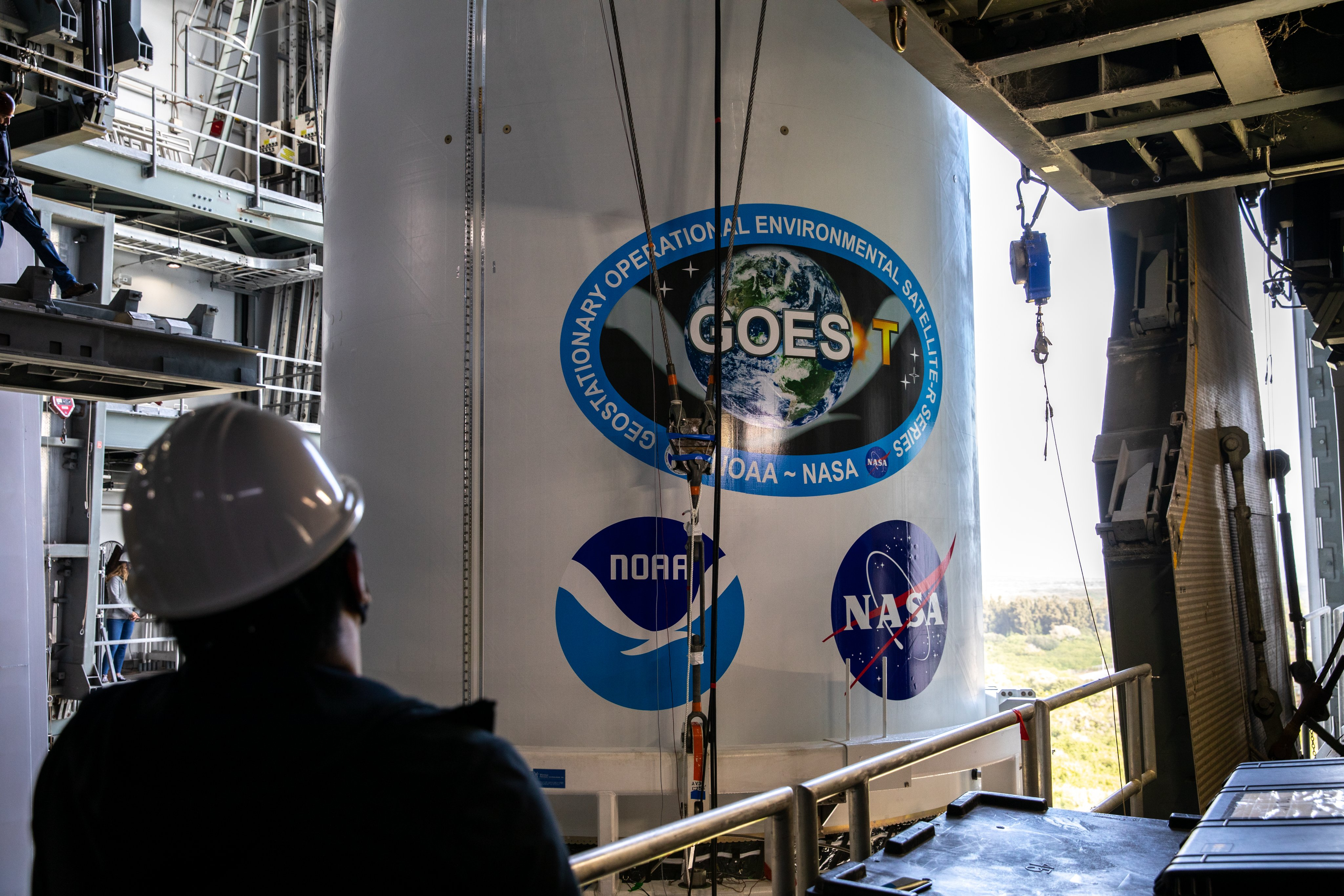 A United Launch Alliance technician monitors the progress of NOAA's GOES-T weather satellite, enclosed in its payload fairing, as it is moved into the Vertical Integration Facility at Space Launch Complex 41 at Cape Canaveral Space Force Station in Florida to meet its Atlas V rocket on Feb. 17, 2022. The satellite will launch on March 1, 2022.