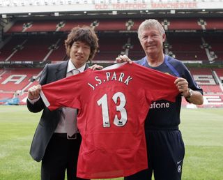 Park Ji-sung holds up his number 13 shirt with manager Sir Alex Ferguson after signing for Manchester United, 2005